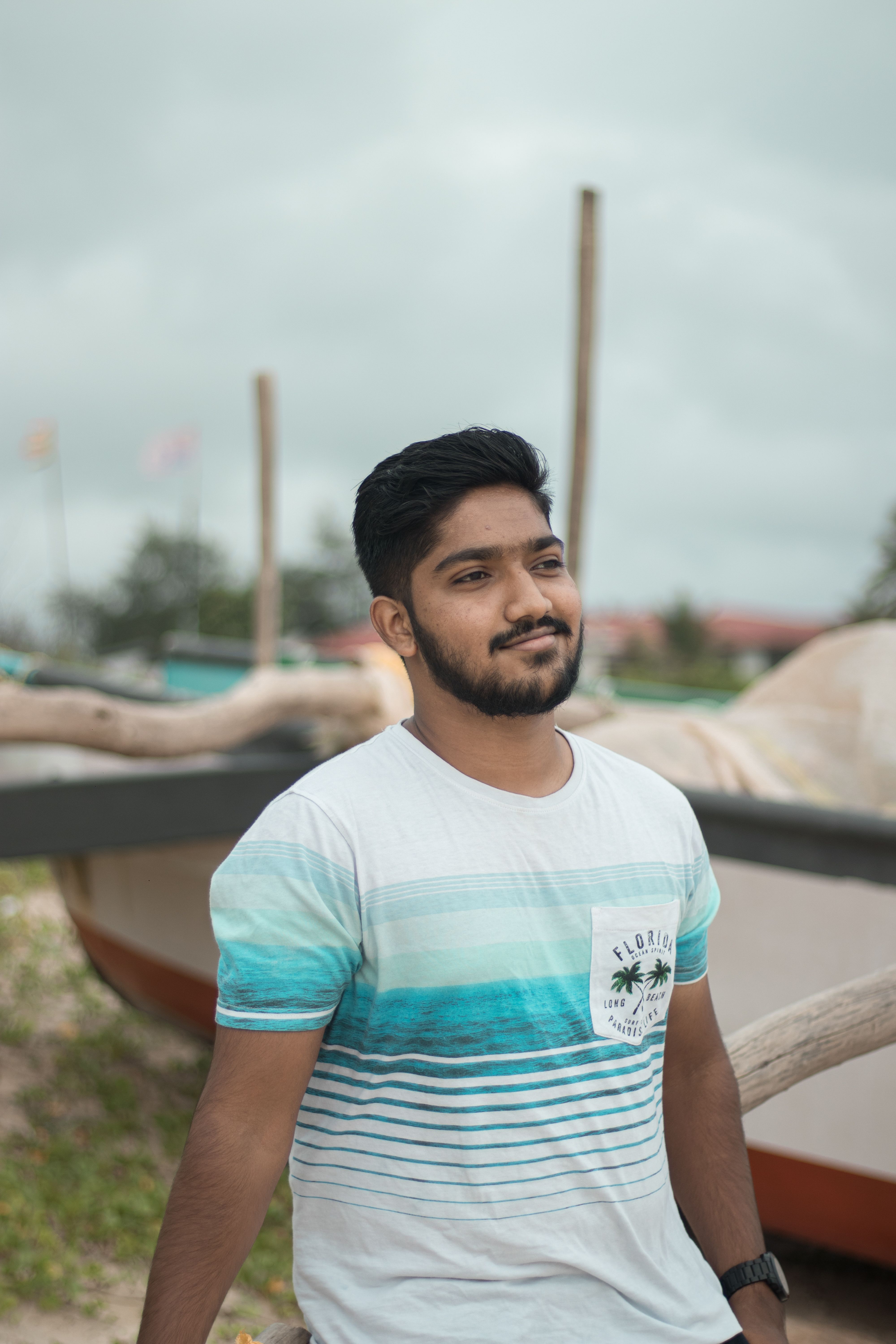 Portrait of a man with a beard in a casual outdoor setting, wearing a graphic tee.
