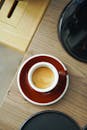 White and Red Ceramic Mug With Brown Liquid Inside