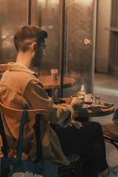 A man enjoying a quiet moment at a coffee shop table, creating a warm and inviting atmosphere.