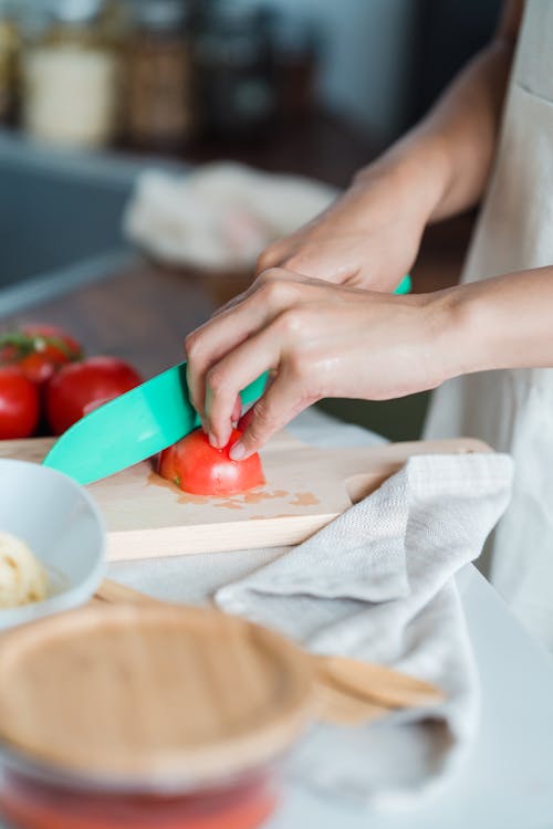 Close-Up Shot of a Person Slicing Tomatoes