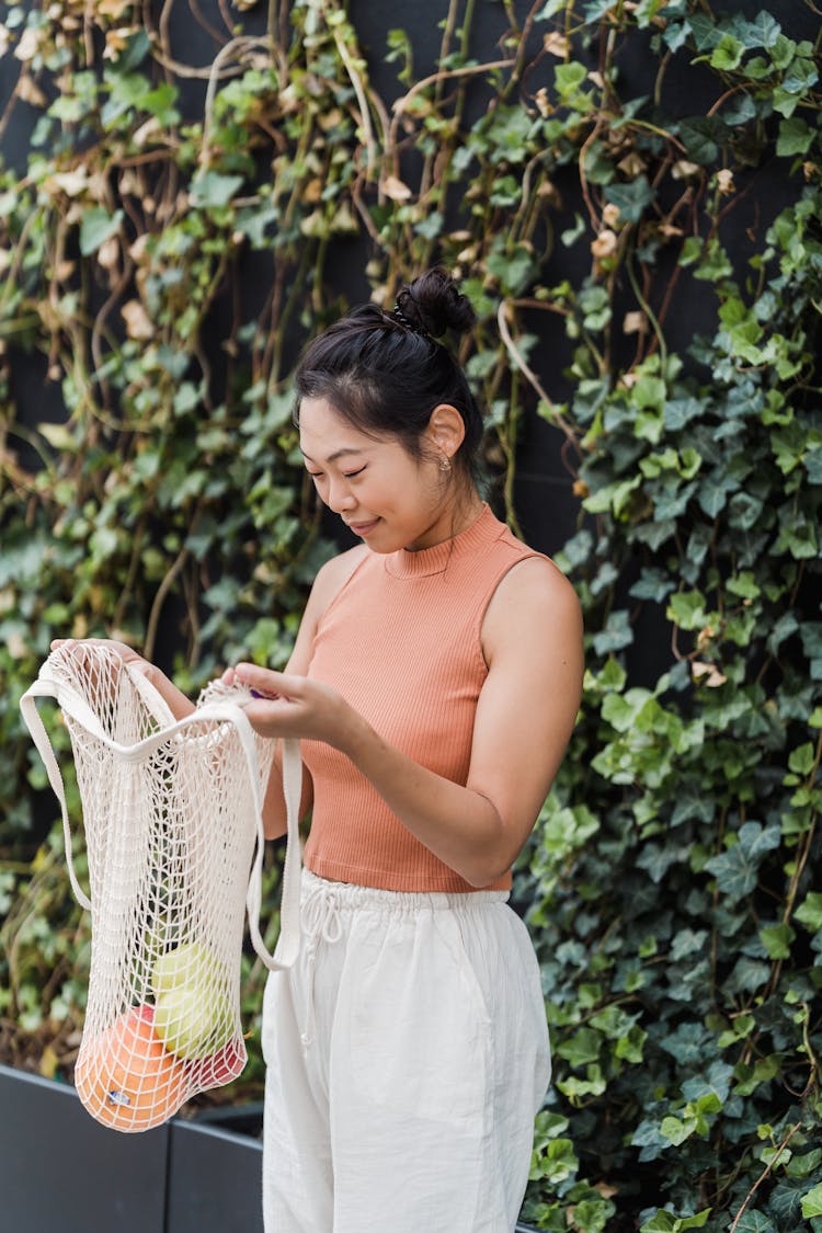 A Woman Holding A String Bag