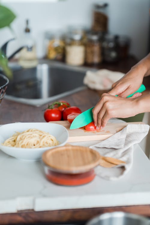 Close-Up Shot of a Person Slicing Tomatoes