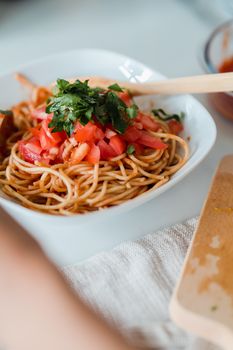 Appetizing spaghetti dish topped with fresh tomatoes and herbs, perfect for a healthy meal.