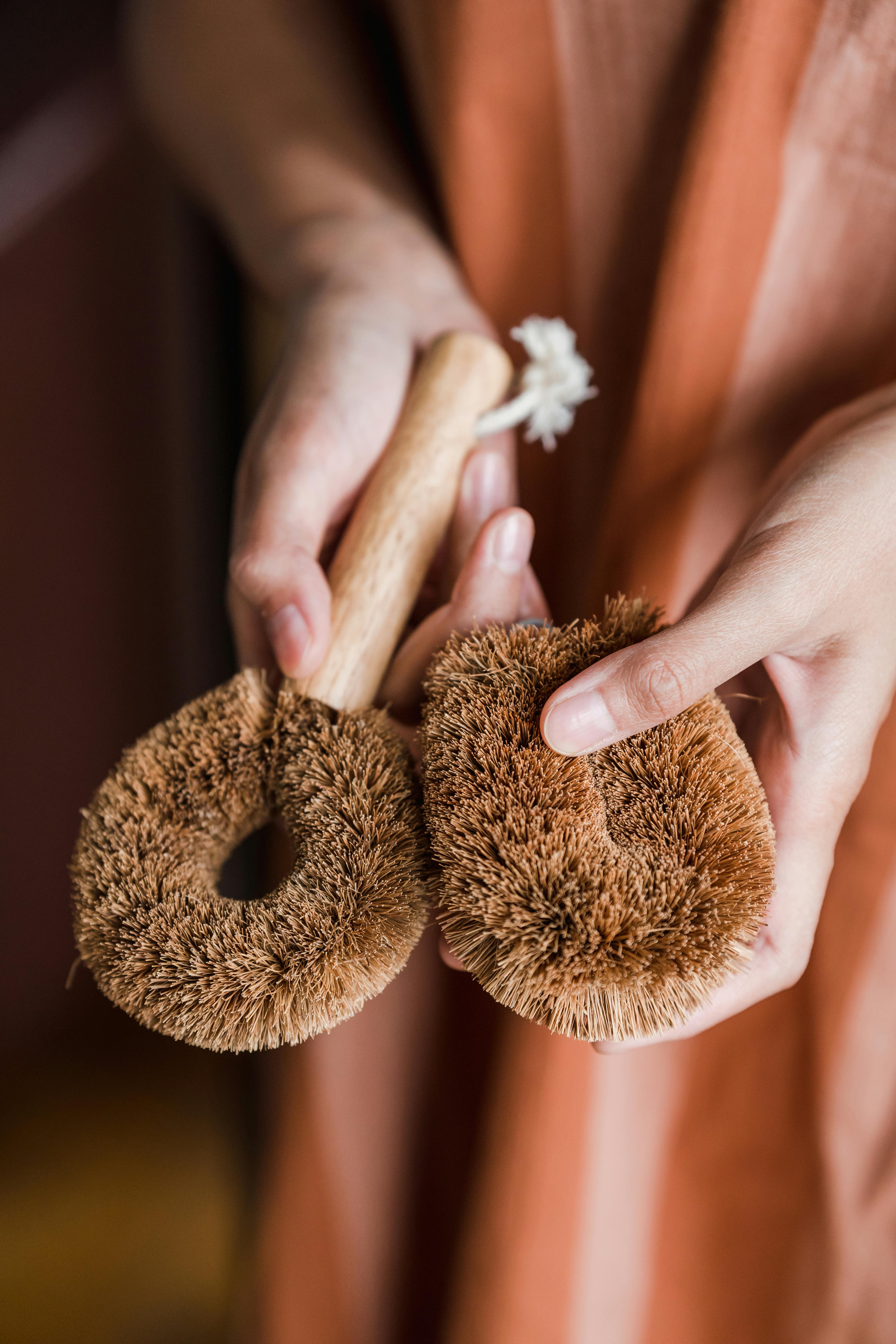 Close-up of hands holding eco-friendly natural scrub brushes for personal hygiene.