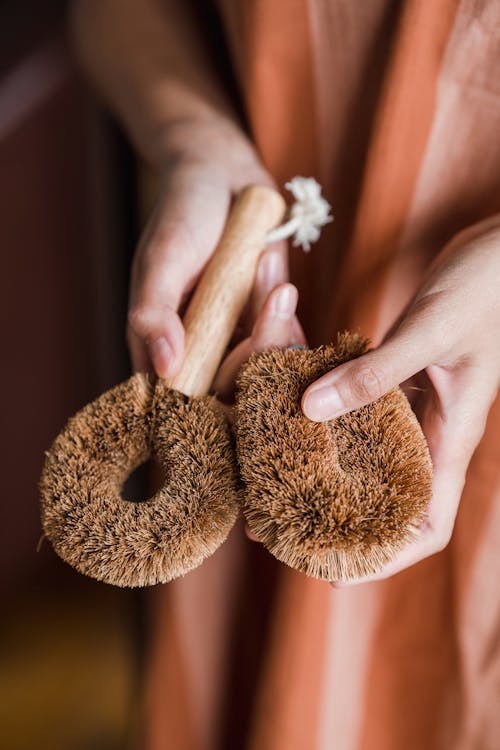 Close-Up Photo of a Person Holding a Brown Body Brush