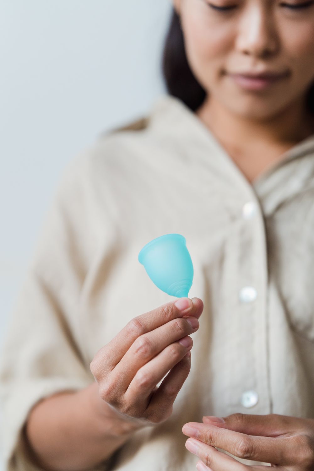 Mulher segurando coletor menstrual, representando alternativas não hormonais e consciência do ciclo natural