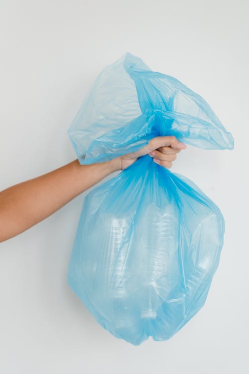 Close-Up Shot of a Person Holding a Blue Plastic Bag