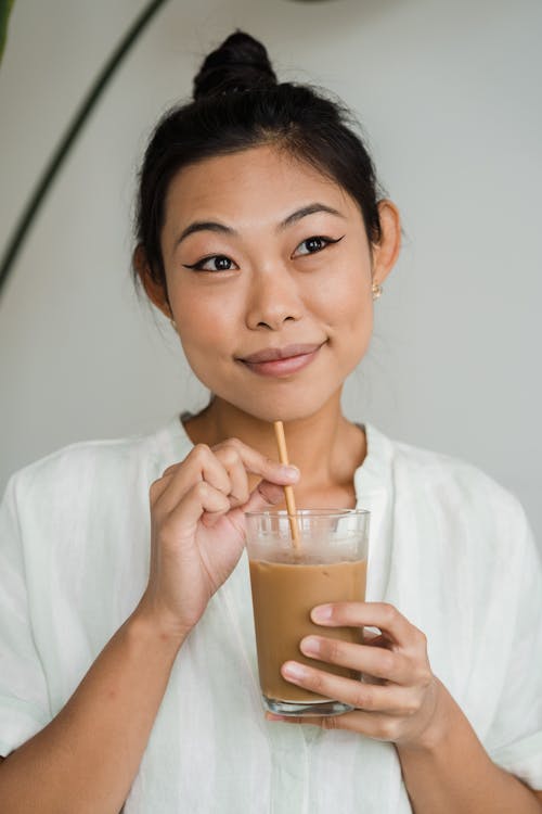 Woman Holding a Glass of Iced Coffee