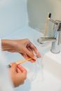 Close-Up Photo of a Person Rinsing Her Toothbrush