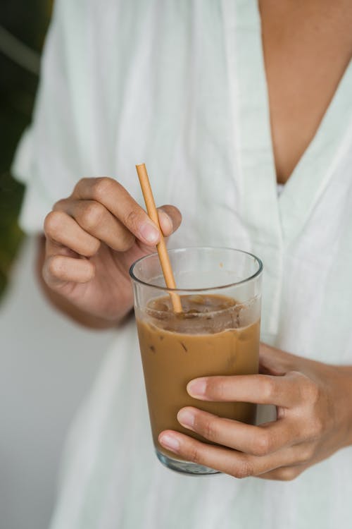 Close-Up Shot of a Person Holding a Glass of Iced Coffee