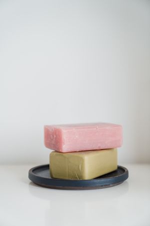 Two soap bars stacked on a tray — photo by Greta Hoffman on Pexels