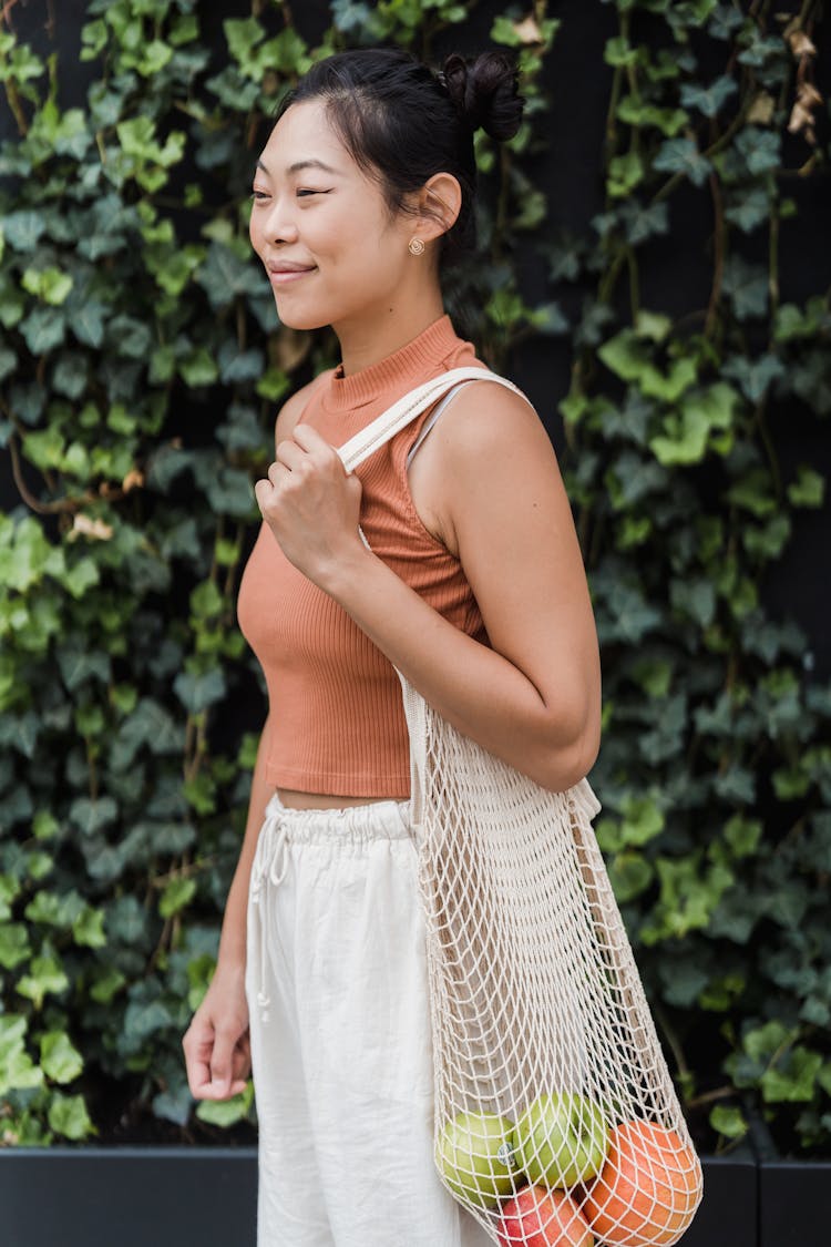 Smiling Woman Carrying A Mesh Tote Bag