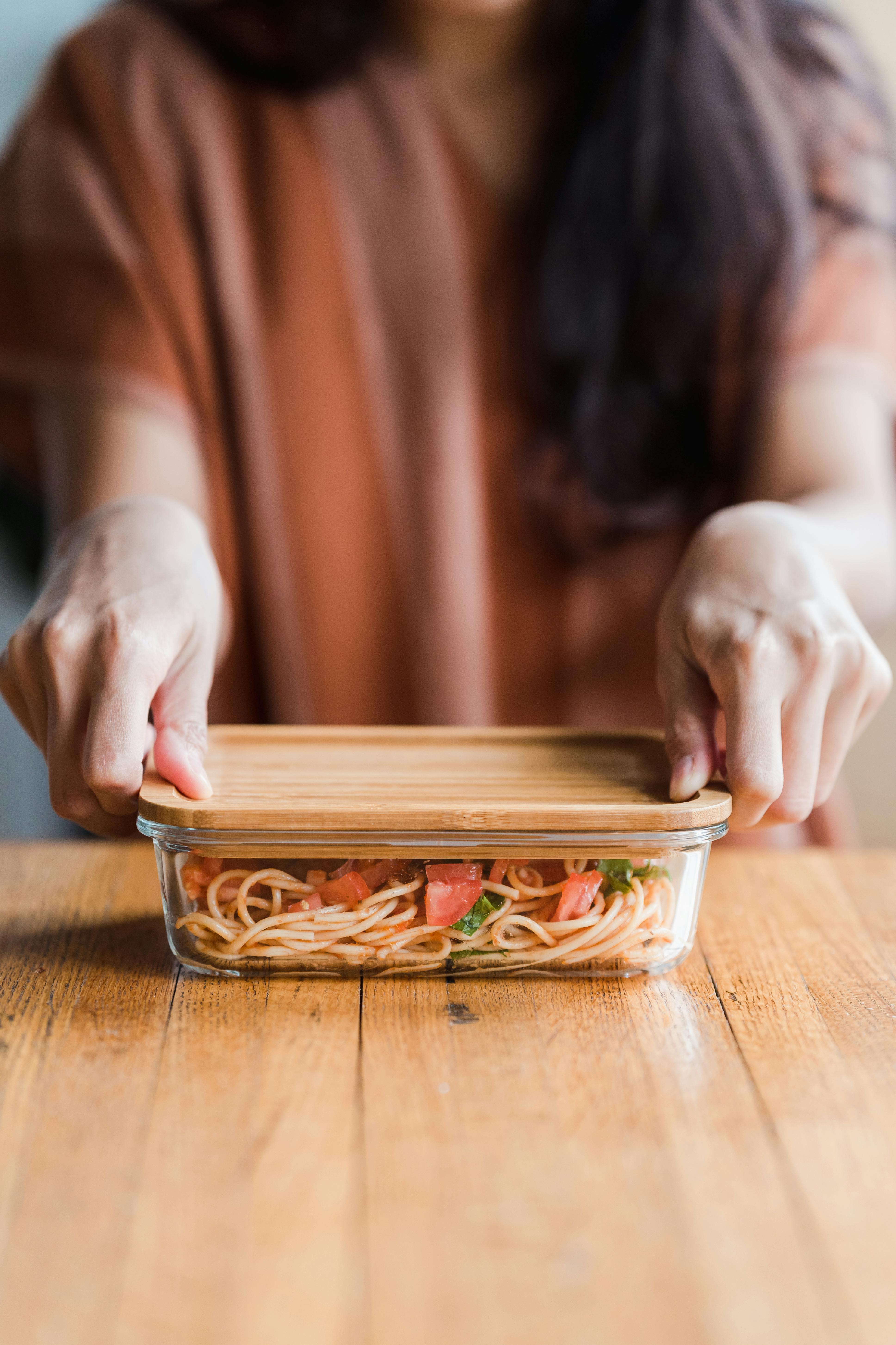 a person holding the lid of a food container