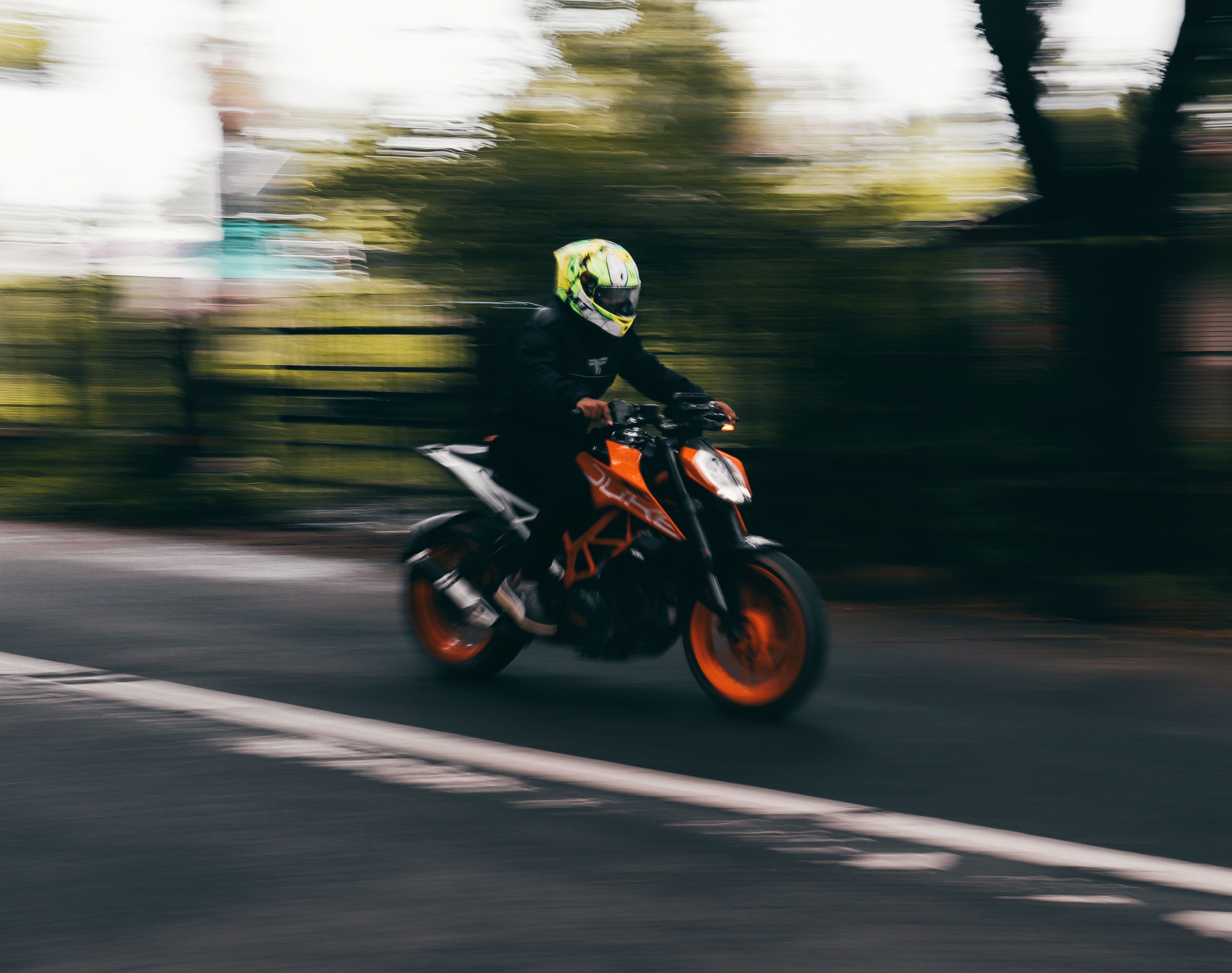 A motorcyclist speeding on a road, captured in a dynamic motion blur, depicting speed and urban adventure.
