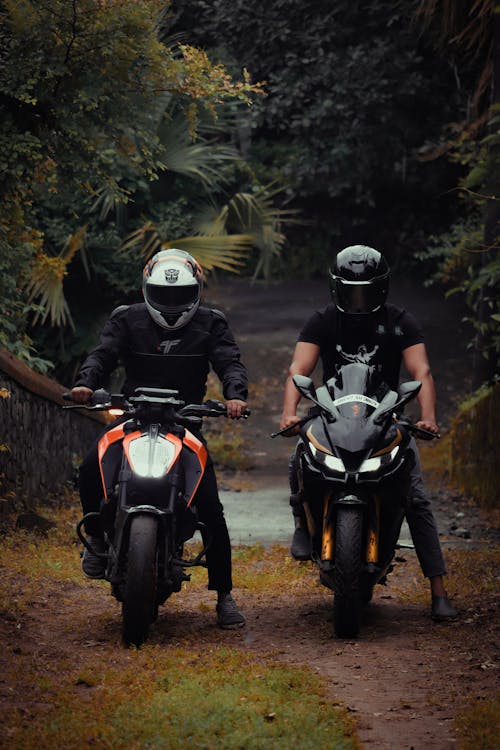 People Riding a Motorcycle while Wearing Helmets