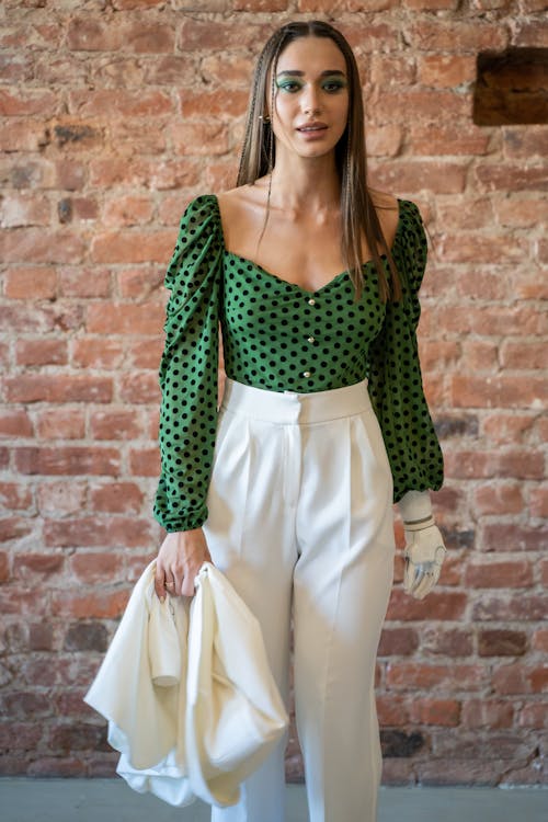 Woman Wearing a Green Polka Dot Shirt and White Pants