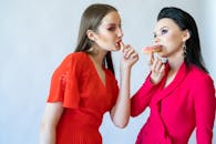 Two Women Posing with Donut