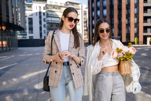 Free Two fashionable women enjoying a sunny day in the city, showcasing modern style and friendship. Stock Photo