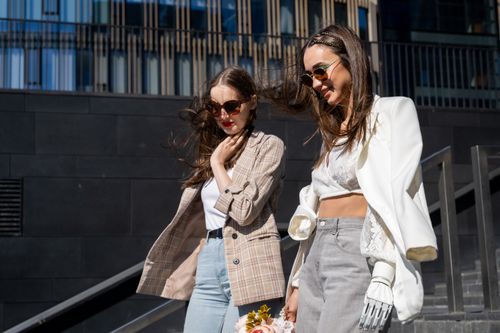 Free Two stylish young women walking together in a modern urban setting. Stock Photo