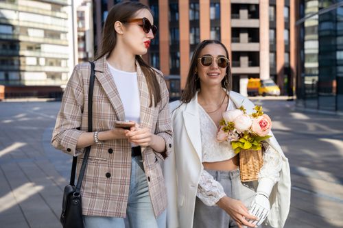 Free Two fashionable women walking outdoors, one with a prosthetic arm, showcasing elegance and confidence. Stock Photo