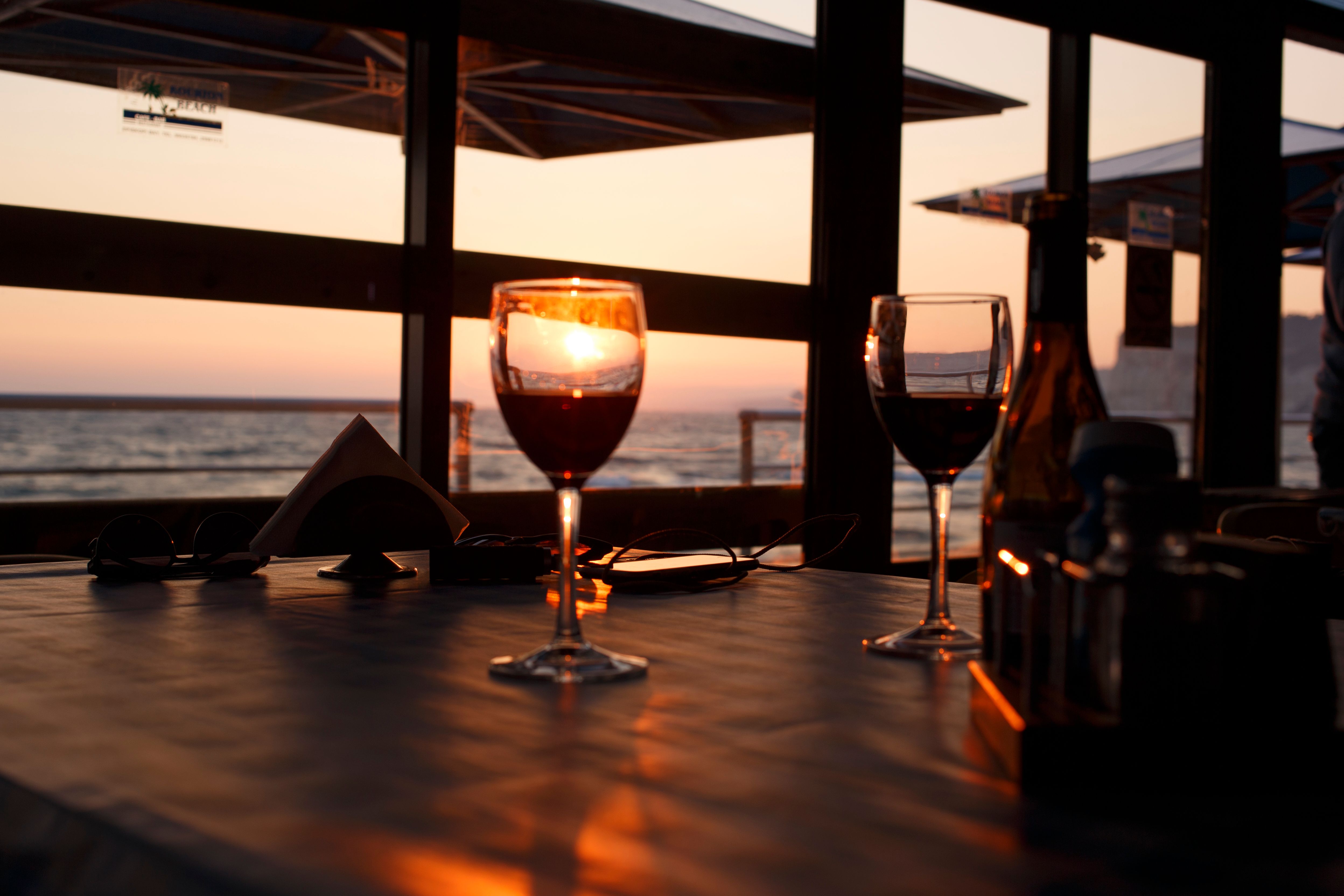 An elegant table set for dinner by the ocean at sunset
