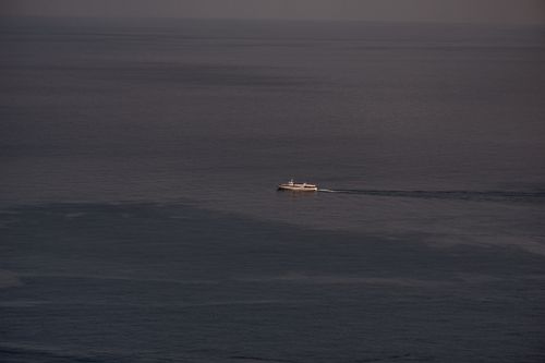Free A lone ship sails through a vast, calm ocean seen from above, evoking a sense of tranquility. Stock Photo