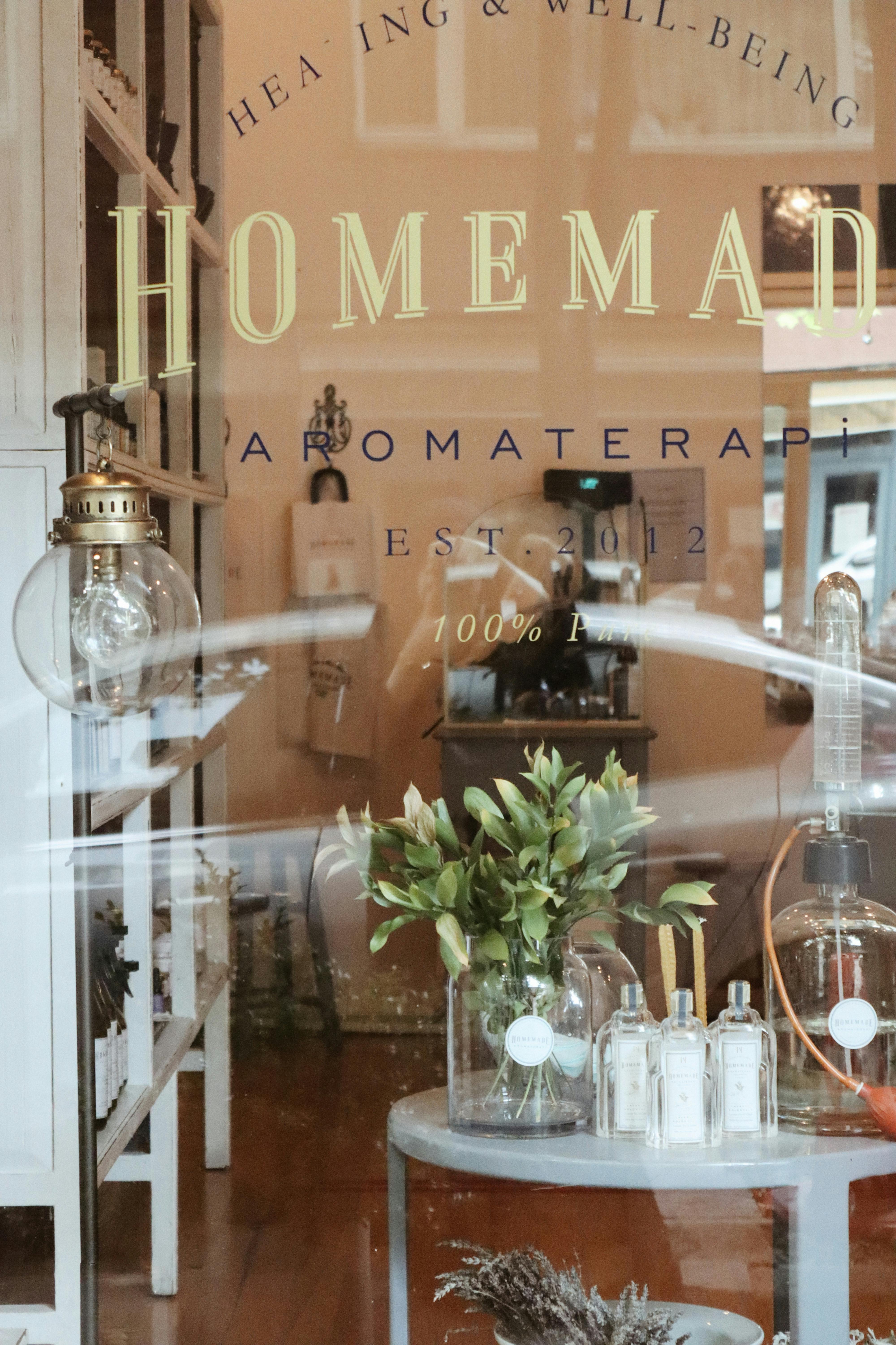 Rustic aromatherapy shop window with decor and wellness products on display.