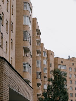 Low angle shot of multi-story brick apartment buildings against a white sky.