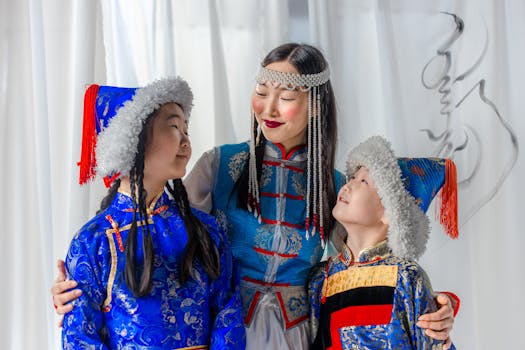 A family in vibrant Mongolian traditional attire, smiling and embracing indoors.