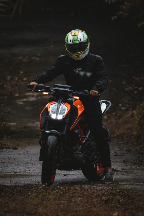 Free Rider on a powerful bike cruising a dirt road with protective gear. Stock Photo