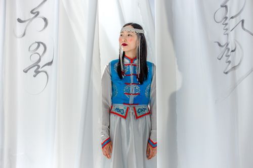 Free Elegant portrait of an Asian woman in traditional clothes with calligraphy in a studio setting. Stock Photo