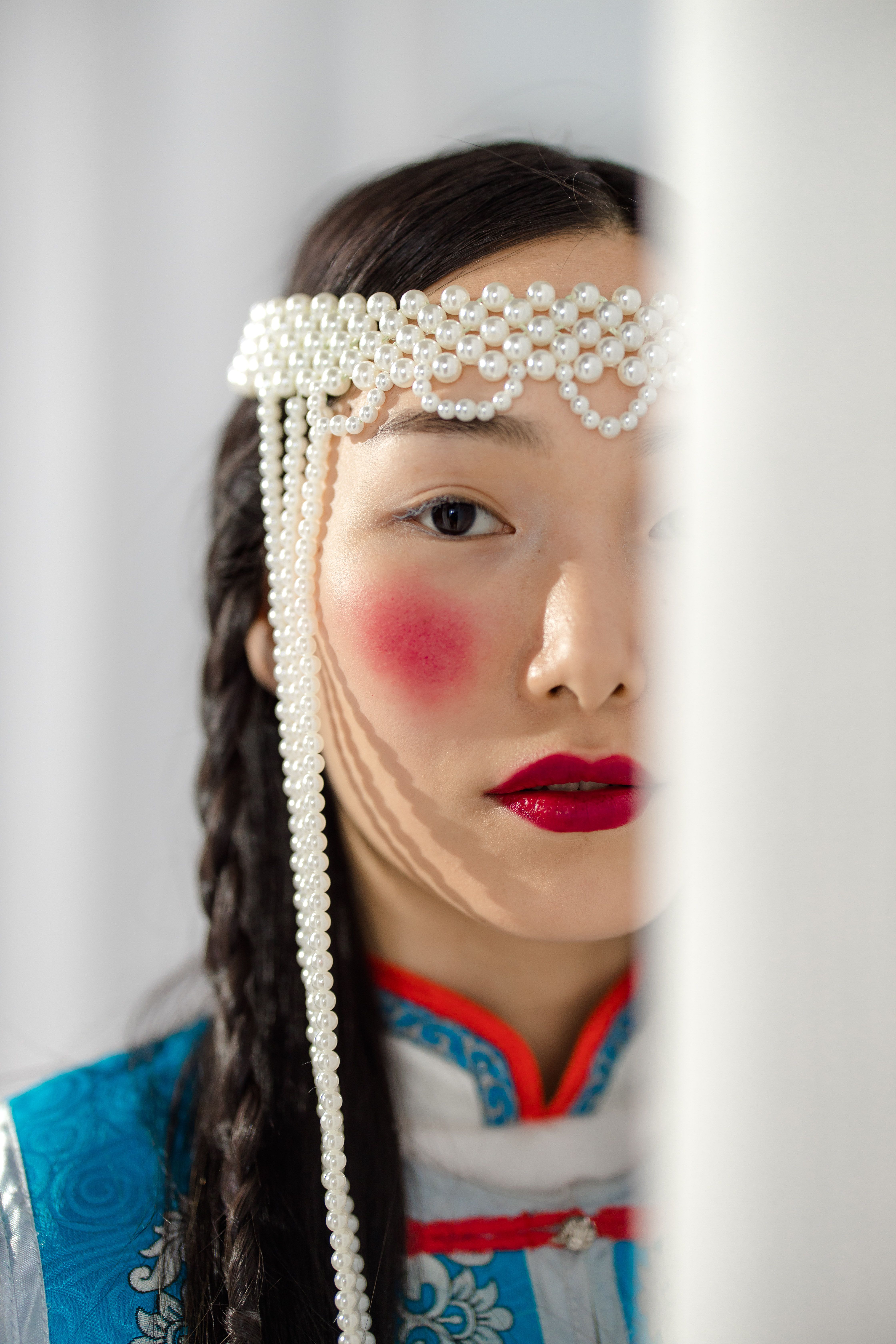 Close-up of a woman in traditional Mongolian attire with pearl headpiece.