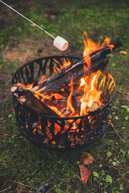 A cozy outdoor scene of a marshmallow roasting over a bright, crackling campfire.