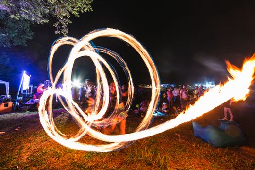 Vibrant fire dancer performance at a night festival in Chattanooga, Tennessee.