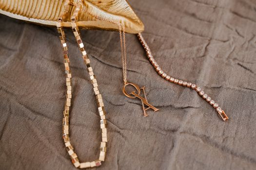 Elegant gold necklaces and diamond bracelet on gray fabric for a chic lifestyle look.
