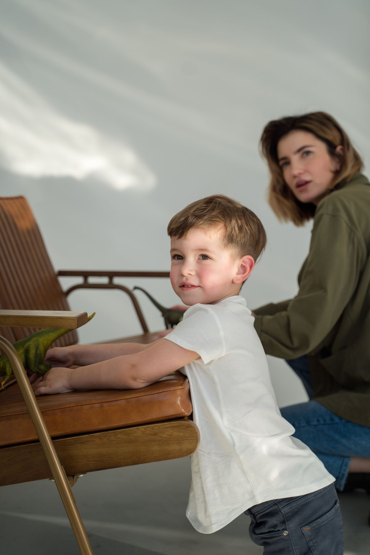 An adult and a child playing together on the floor in natural light