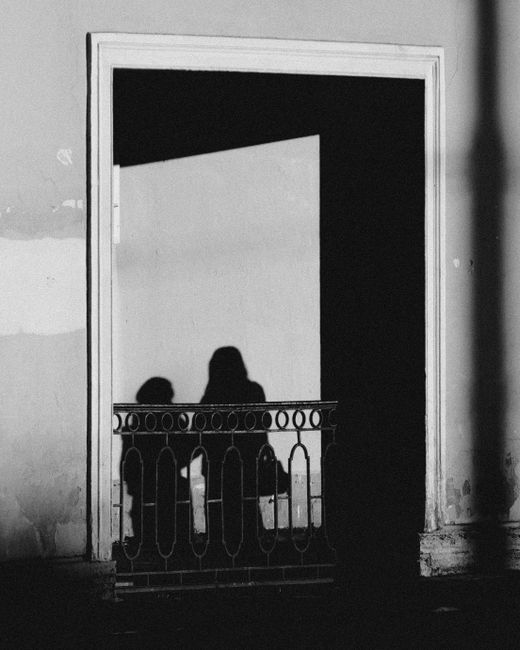 Artistic black and white shadows of people on a balcony in St. Petersburg.