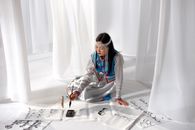Woman in Her Traditional Clothes Holding a Brush for Calligraphy