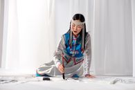Woman in Her Traditional Clothes Holding a Brush for Calligraphy