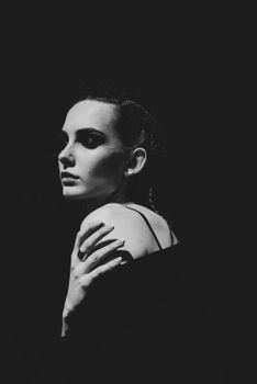 Dramatic studio portrait of a woman in moody black and white tones.