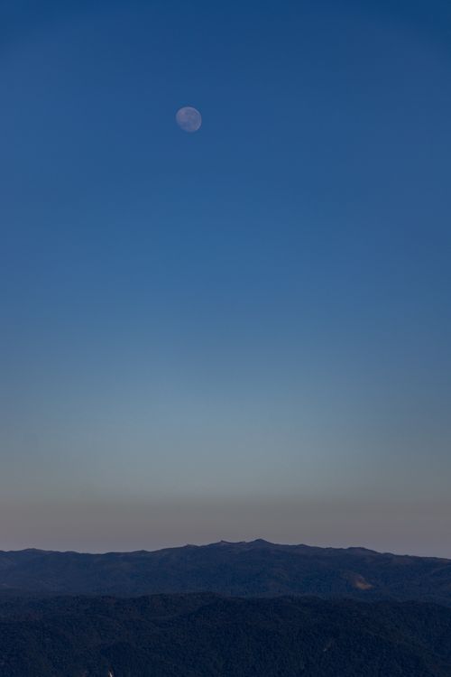 Vague Moon on Blue Sky over Mountains · Free Stock Photo