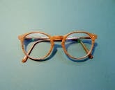 蓝色背景上特写的时尚木框眼镜