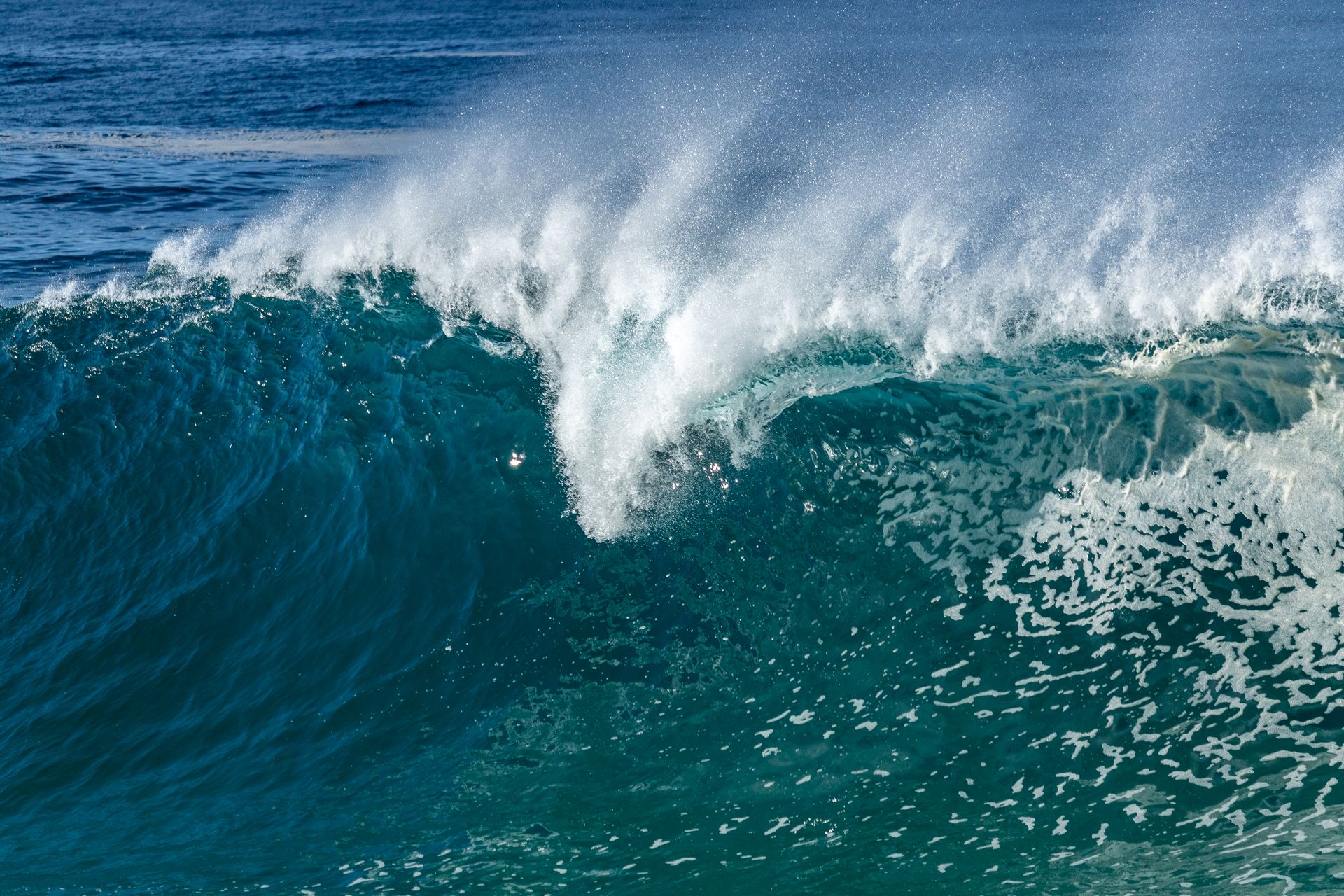 A stunning close-up of a crashing ocean wave, showcasing the vibrant blue and white splash.
