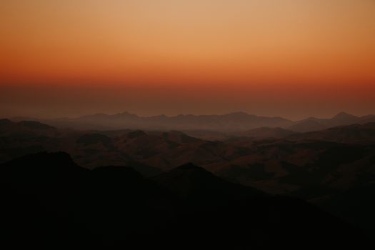 Stunning silhouette of mountain ranges at sunset with a dramatic sky, perfect for nature lovers.
