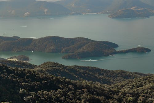 Aerial View of Green Mountain on Body of Water