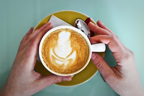 Person Holding White Ceramic Cup