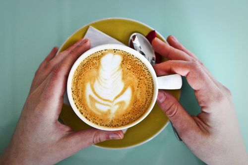 Free Discover the art and warmth of coffee with this beautifully crafted latte adorned with delicate foam art in a cozy café setting. Stock Photo