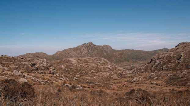 Stunning mountain terrain with clear blue sky, showcasing natural beauty and rocky formations.