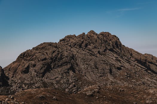 Stunning view of a rocky mountain with a clear blue sky, capturing nature's grandeur and tranquility.