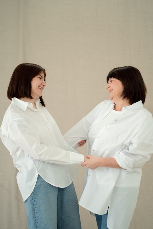 Women in White Long Sleeve Shirt Looking at Each Other